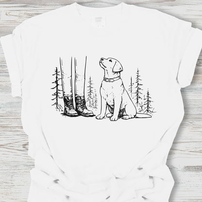 White t-shirt with a black line drawing of a dog sitting in a forest on a wooden surface.