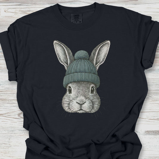Black t-shirt with a graphic of a rabbit wearing a green beanie on a wooden surface