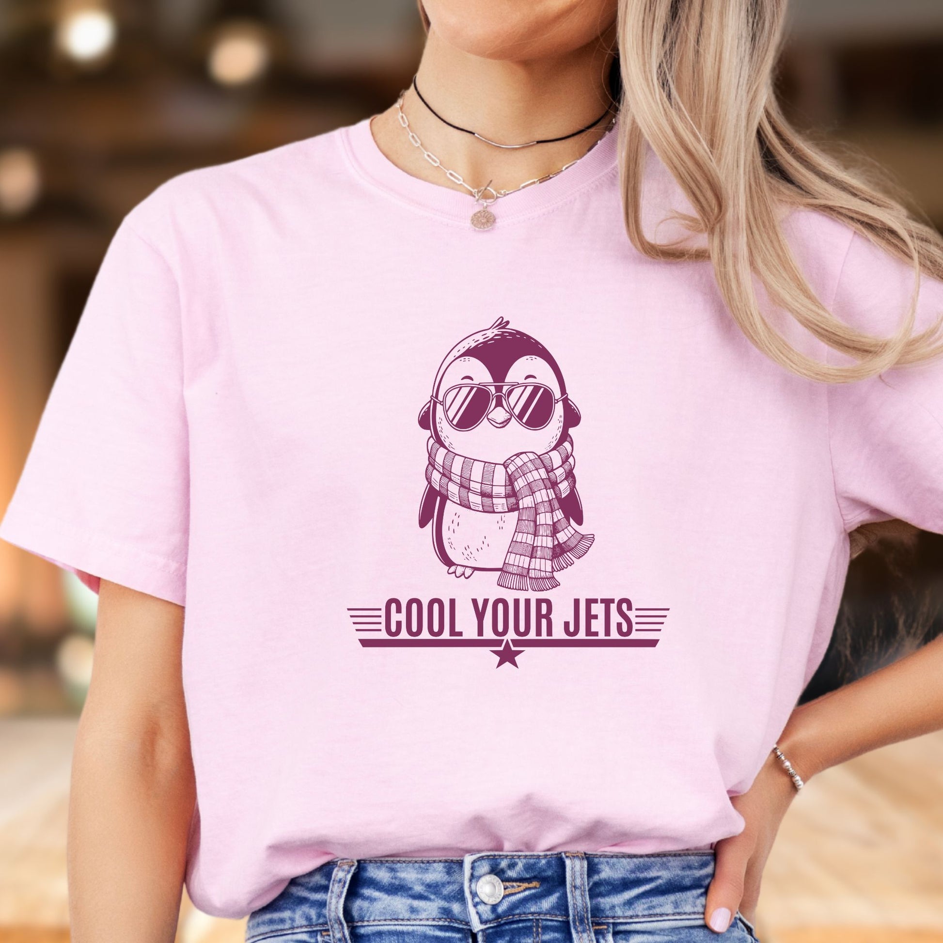 Person wearing a pink t-shirt with a penguin graphic and 'Cool Your Jets' text.