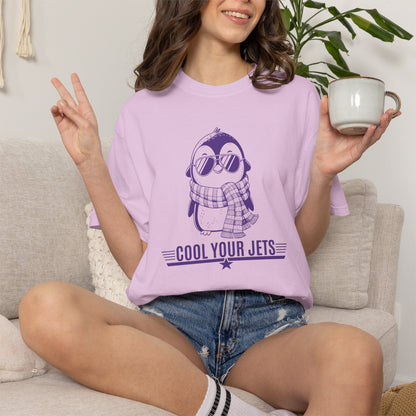 Person wearing a purple t-shirt with a penguin graphic and text, sitting on a couch holding a mug.