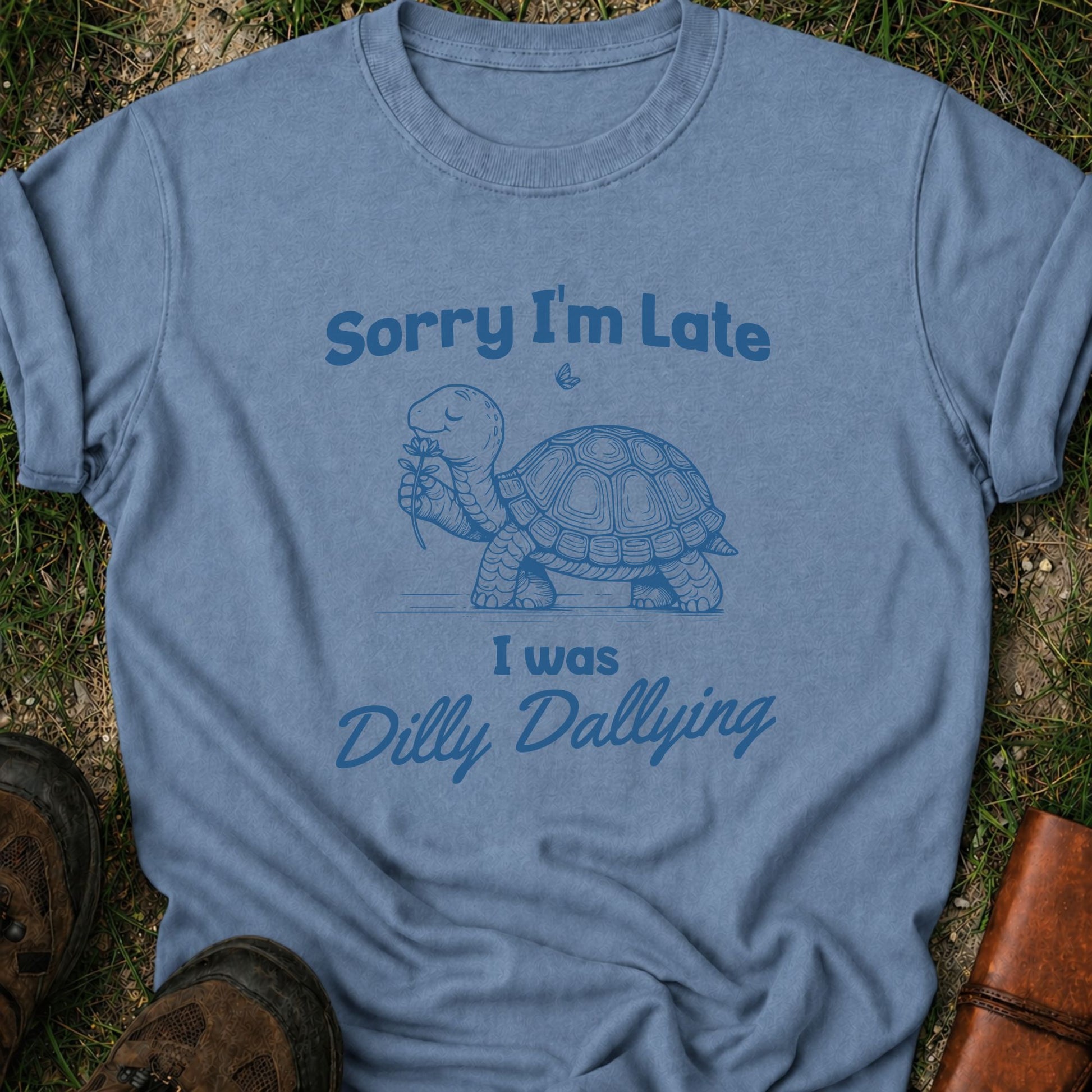 Blue t-shirt with a turtle graphic and text on grass