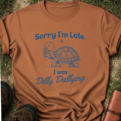 Brown t-shirt with a turtle graphic and text on grass