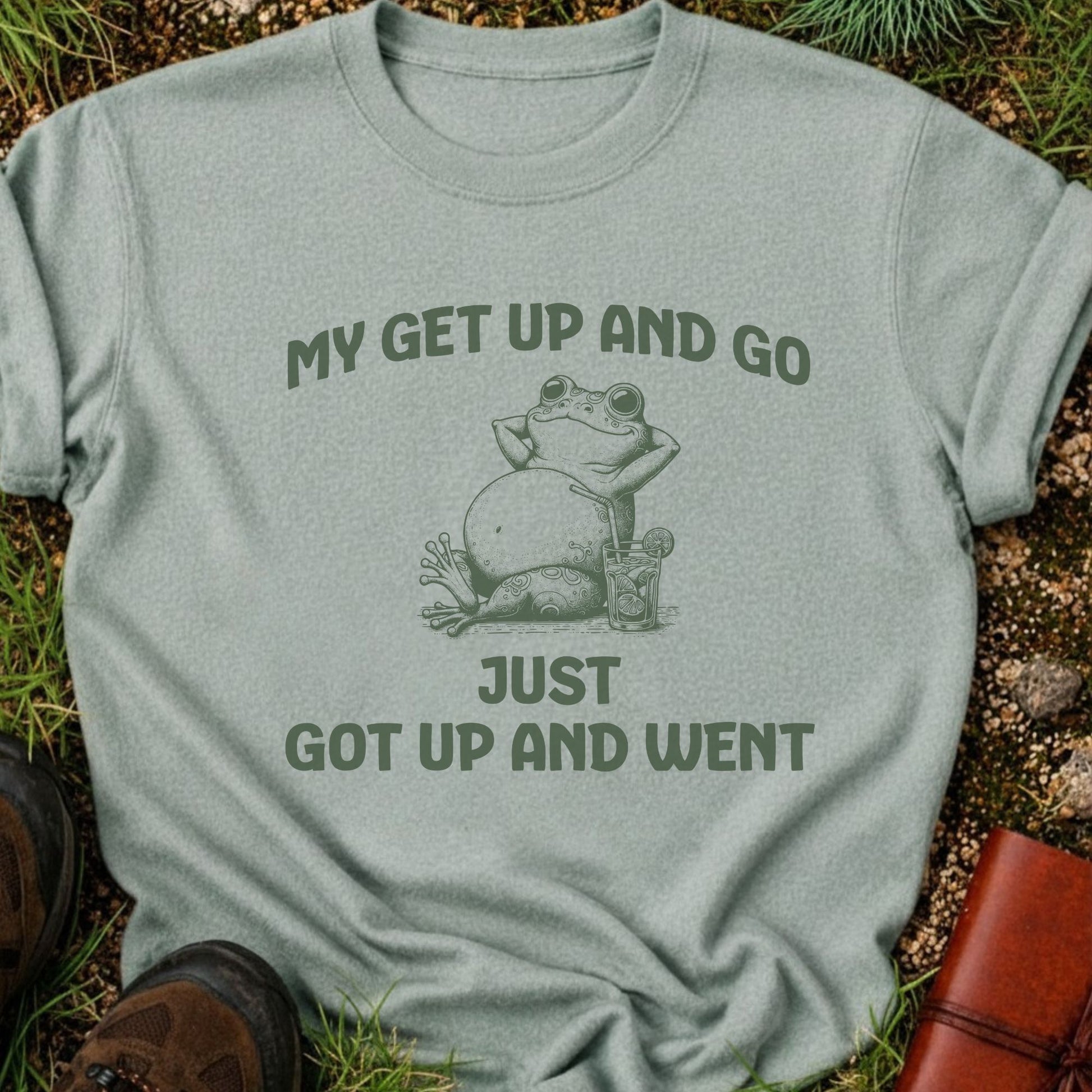 Light gray t-shirt with a frog graphic and text on grass