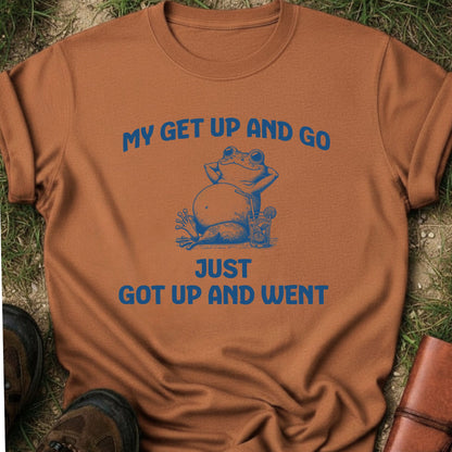 Brown t-shirt with a blue frog graphic and text on grass