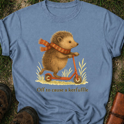 Blue t-shirt with a hedgehog on a scooter graphic and text 'Off to cause a kerfuffle' on grass.
