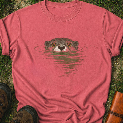 Dark Pink T-shirt with swimming otter design on lyimg on a grassy surface