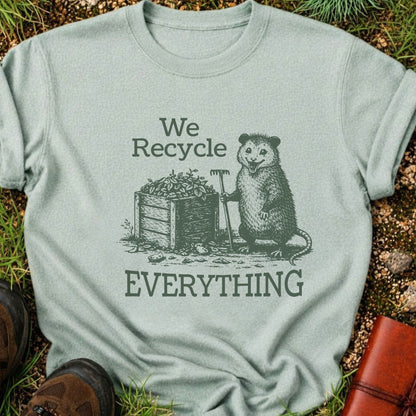 Light Green T-Shirt  featyrubg a vintage-style opossum beside a compost bin with the bold phrase “We Recycle Everything.” 