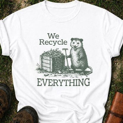 White T-Shirt  featyrubg a vintage-style opossum beside a compost bin with the bold phrase “We Recycle Everything.” 
