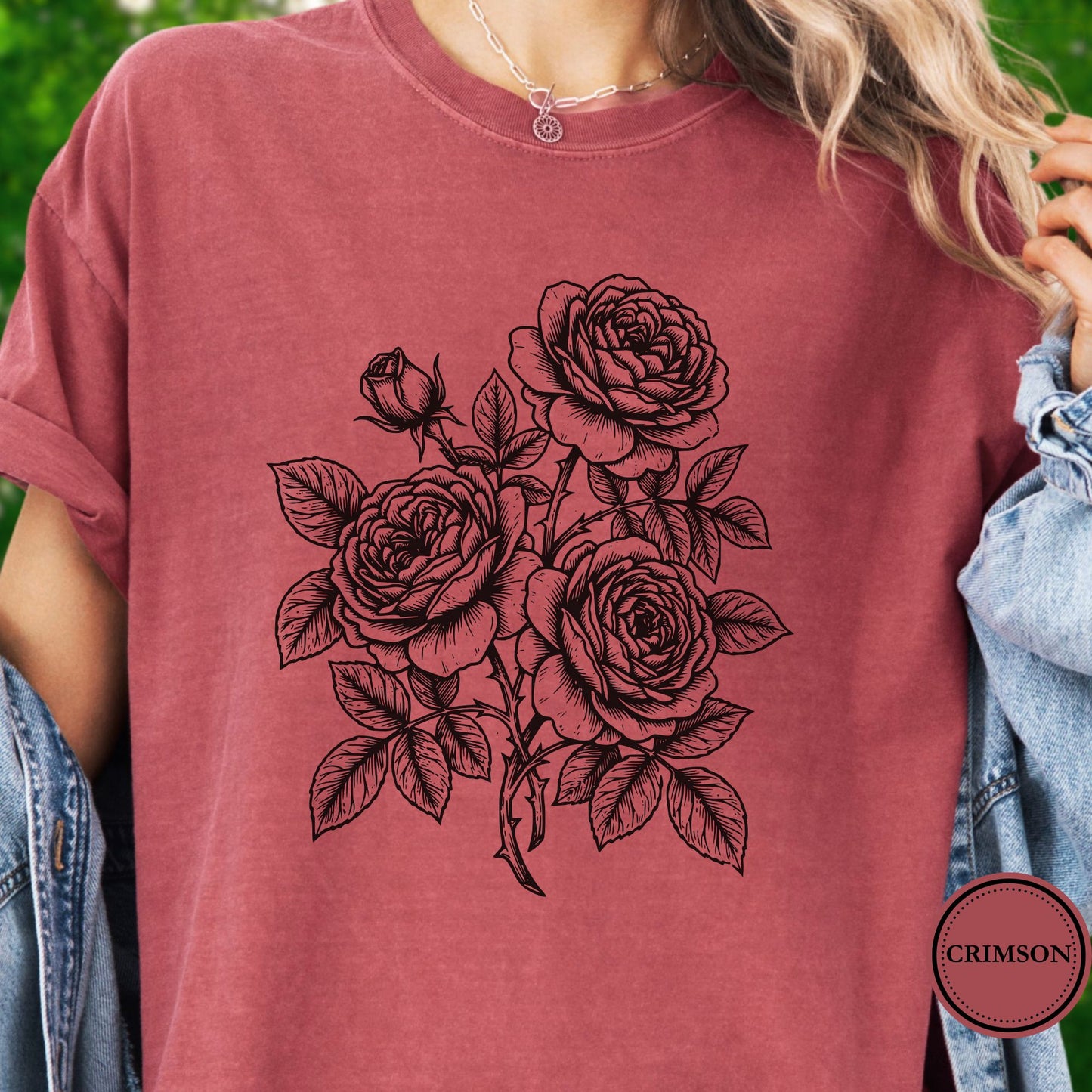 Model wears a Dark Pink Tshirt with a   Graphic showing a minimal black botanical line art design featuring elegant roses with leafy stems