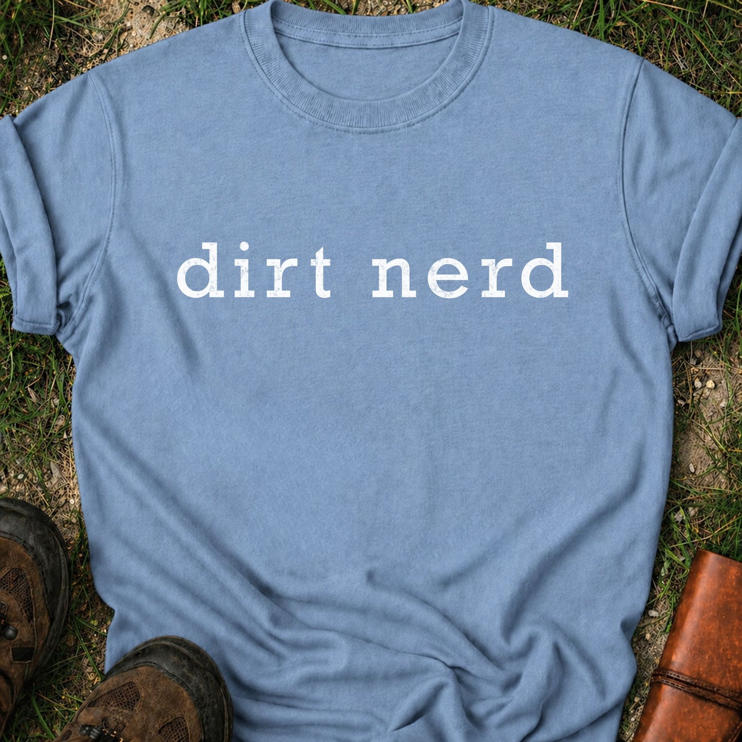 Blue t-shirt with 'dirt nerd' text on grass