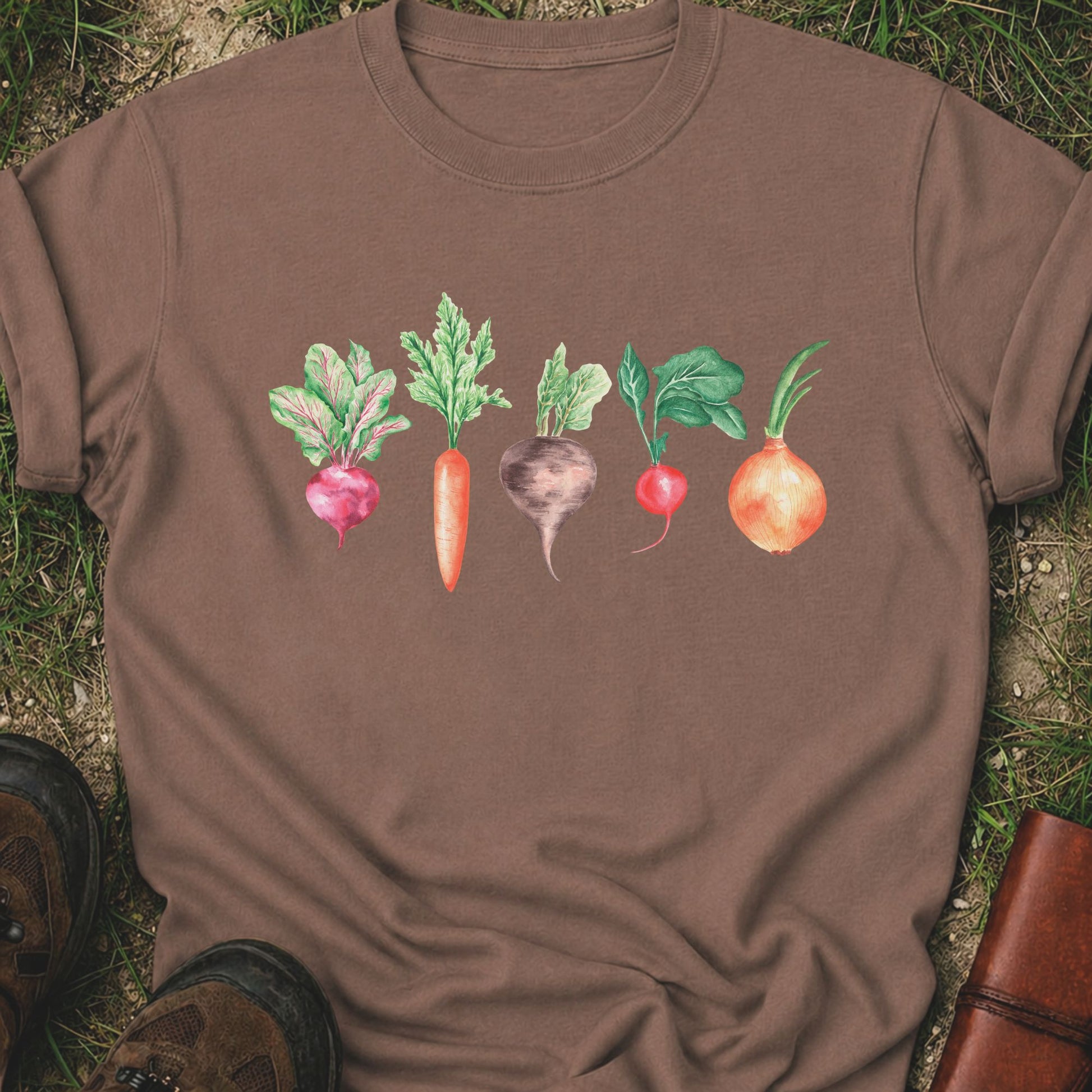 Brown T-shirt with vegetable graphic laying flat  on a grassy surface