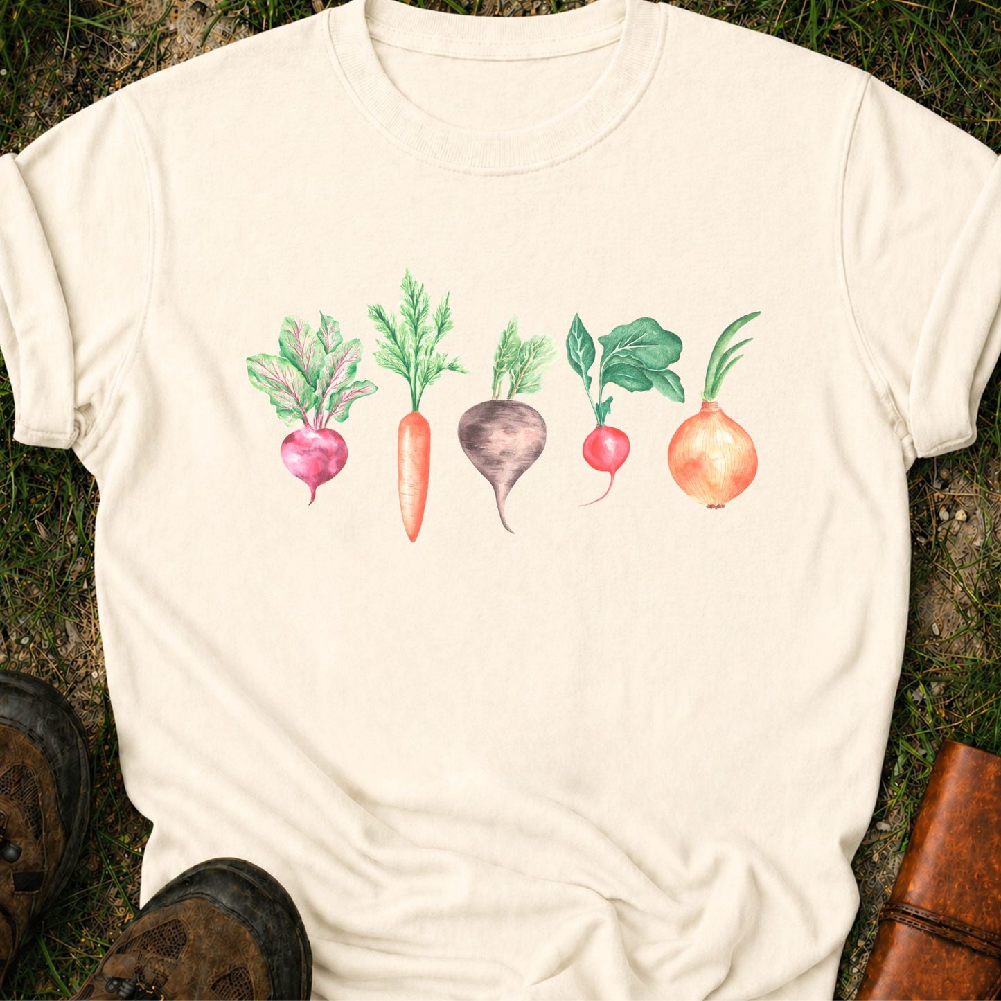 Ivory T-shirt with vegetable graphic laying flat  on a grassy surface