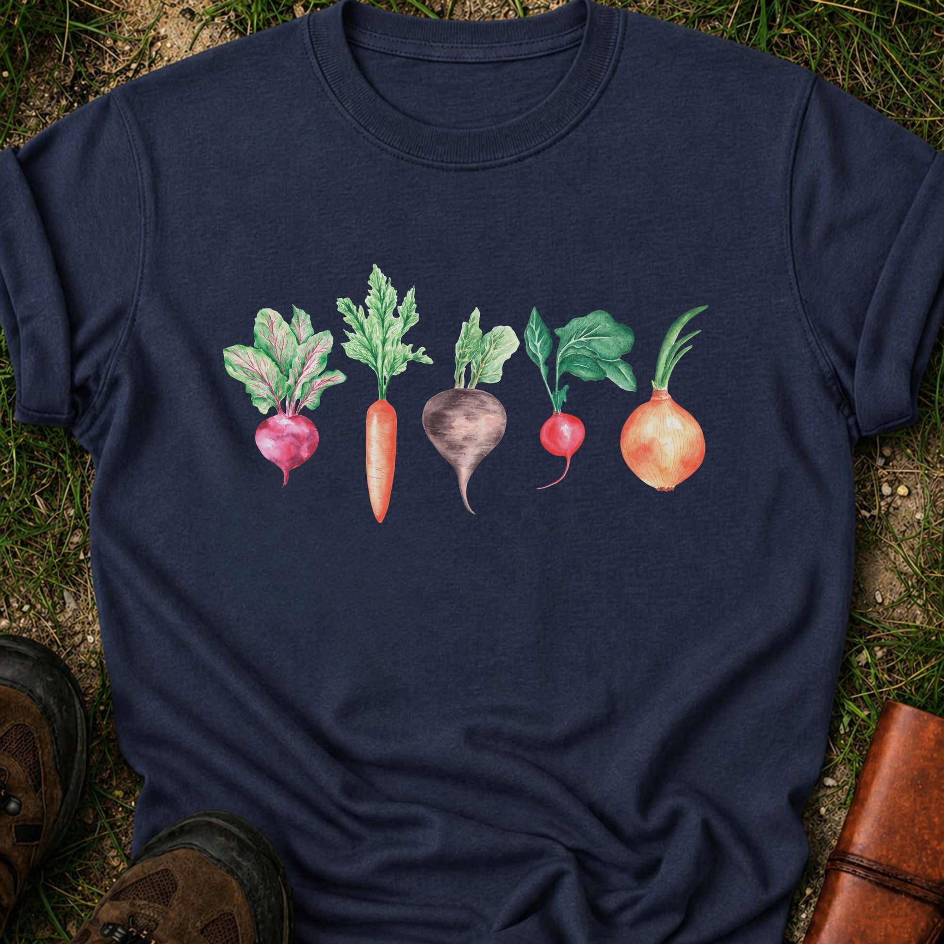 Navy T-shirt with vegetable graphic laying flat  on a grassy surface