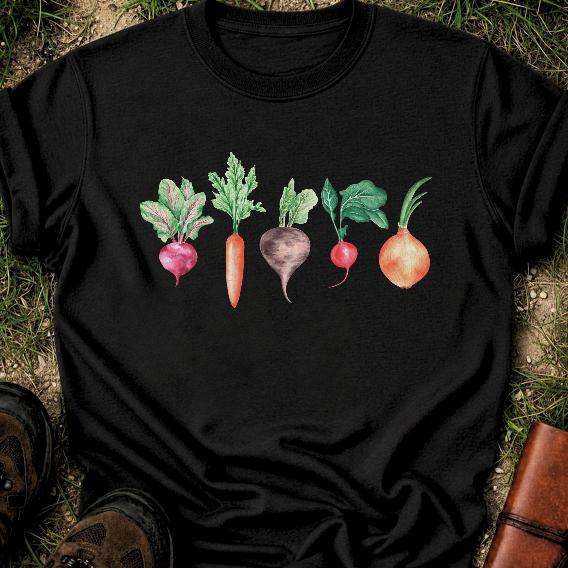 Black T-shirt with vegetable graphic laying flat  on a grassy surface