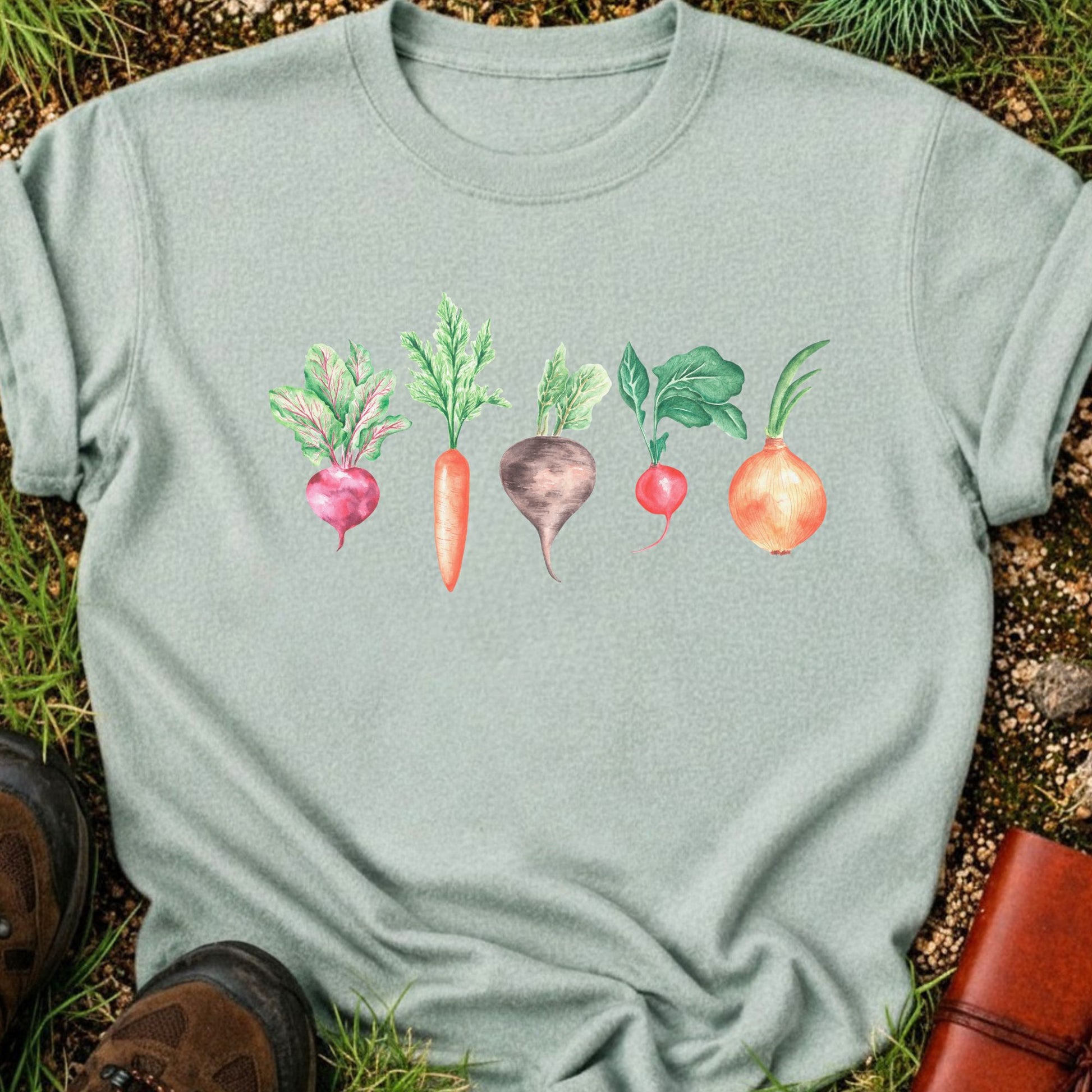 Light Green T-shirt with vegetable graphic laying flat  on a grassy surface