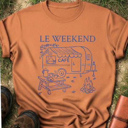 Orange  t-shirt with blue graphic and 'LE WEEKEND CAFé' text on grass