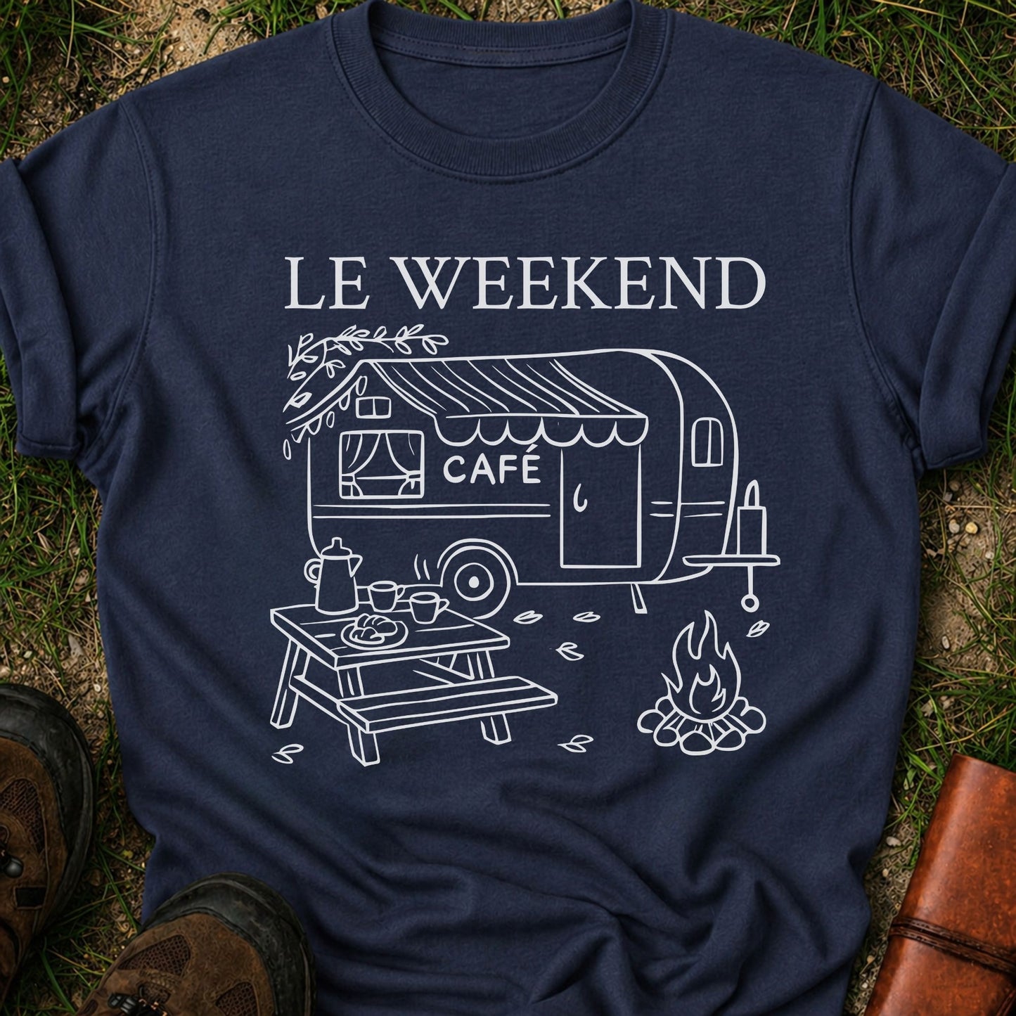 Navy blue t-shirt with white graphic design of a camper and 'Le Weekend Cafe' text on grass.