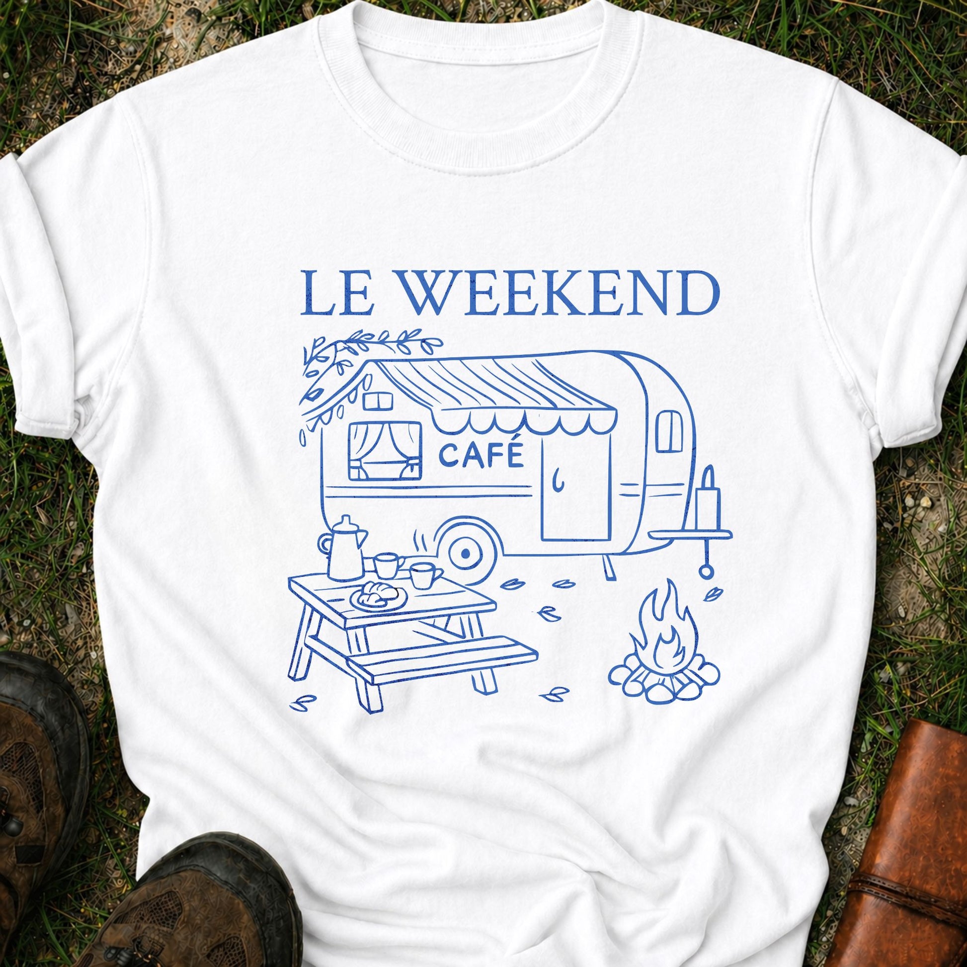 White t-shirt with blue graphic and 'LE WEEKEND CAFé' text on grass