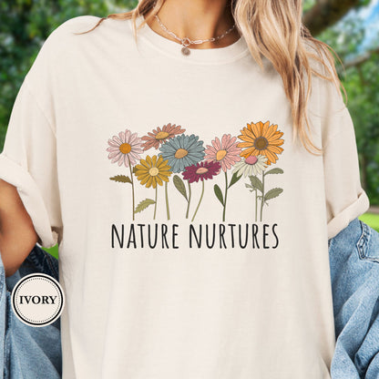 Model Wears an Ivory t-shirt with colorful floral design and 'Nature Nurtures' text 