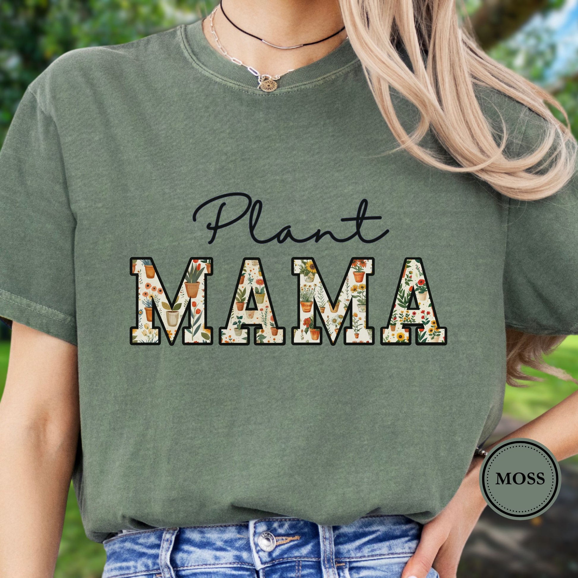 Model wears a green t-shirt with 'Plant MAMA' text filled with cheerful potted plants and florals within the letters. 