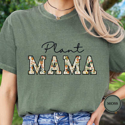Model wears a green t-shirt with 'Plant MAMA' text filled with cheerful potted plants and florals within the letters. 