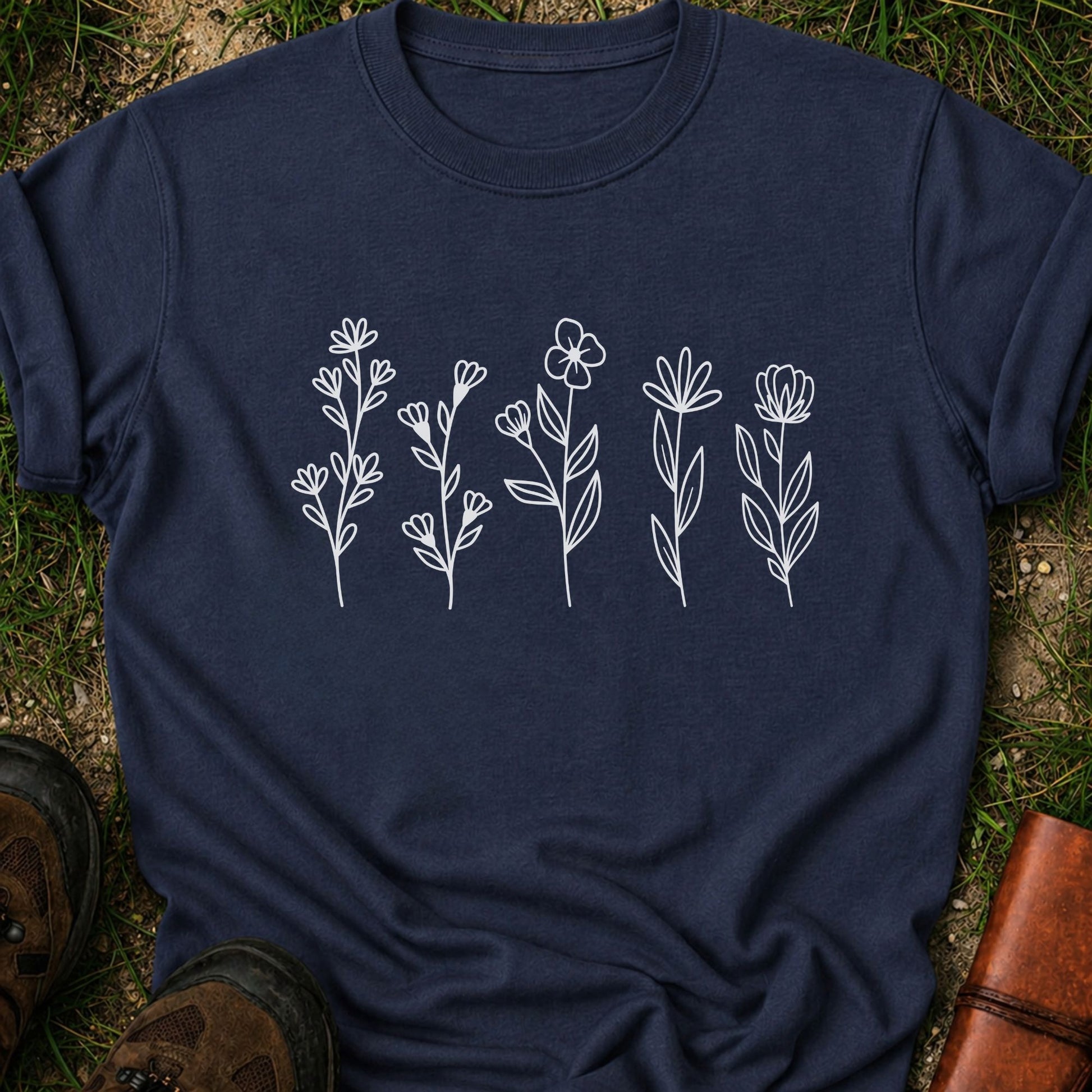 Navy blue t-shirt with white floral designs on grass