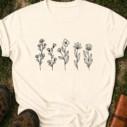 Ivory t-shirt with black floral designs on grass