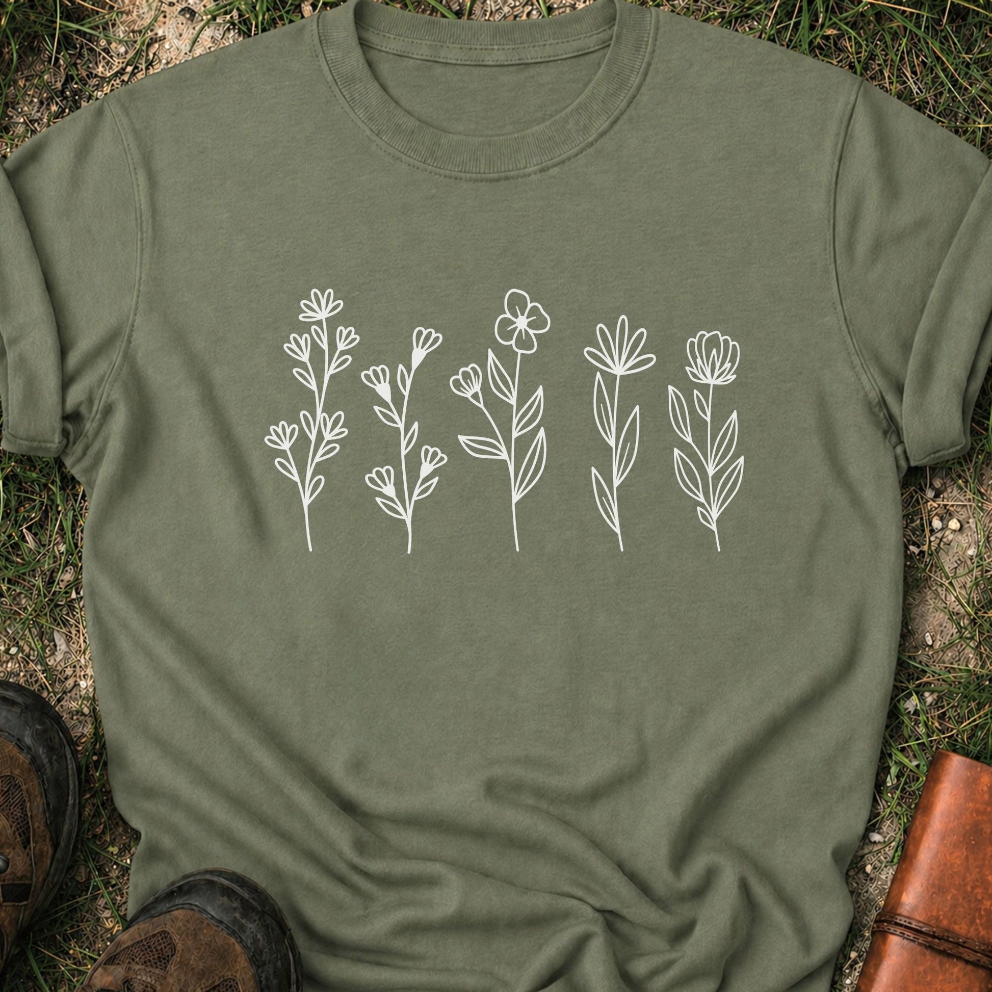 Green t-shirt with white floral designs on grass