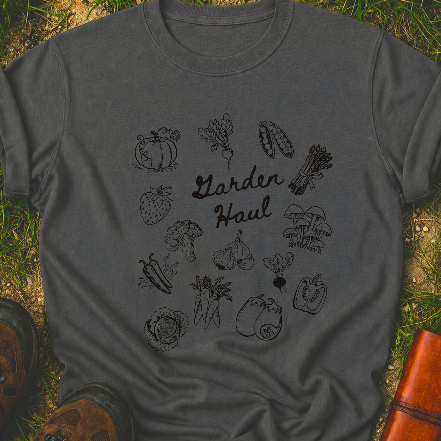 Dark gray t-shirt with black vegetable illustrations and 'Garden Haul' text on grass.