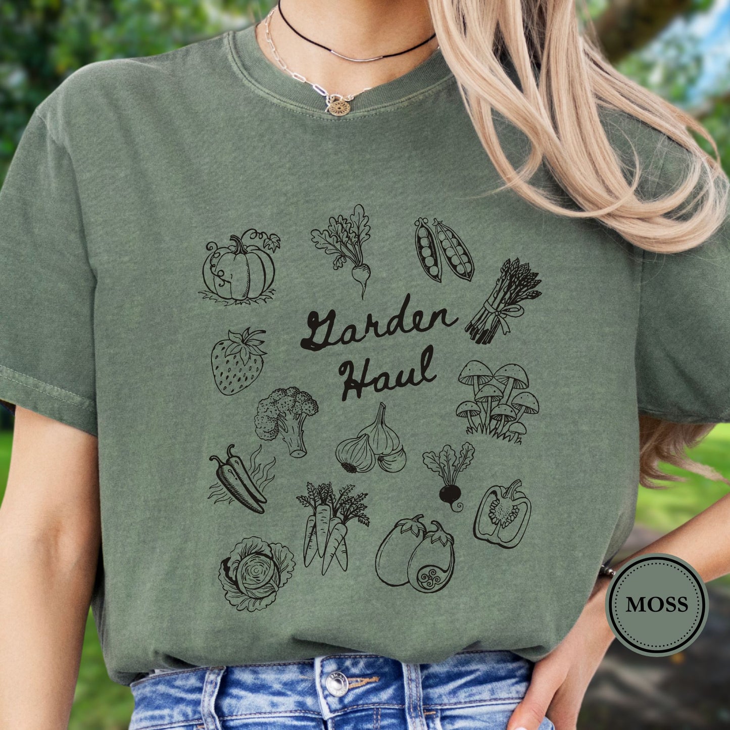 Person wearing a green t-shirt with vegetable illustrations and 'Garden Haul' text, standing outdoors.