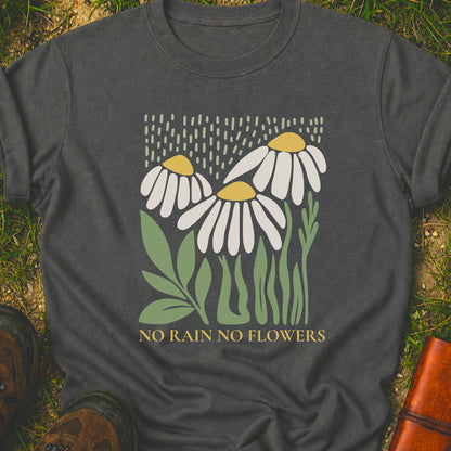 Dark Grey T-Shirt with 3 boho style flowers in the rain with the text "No Rain No Flowers".  Tshirt is lying flat on grass.