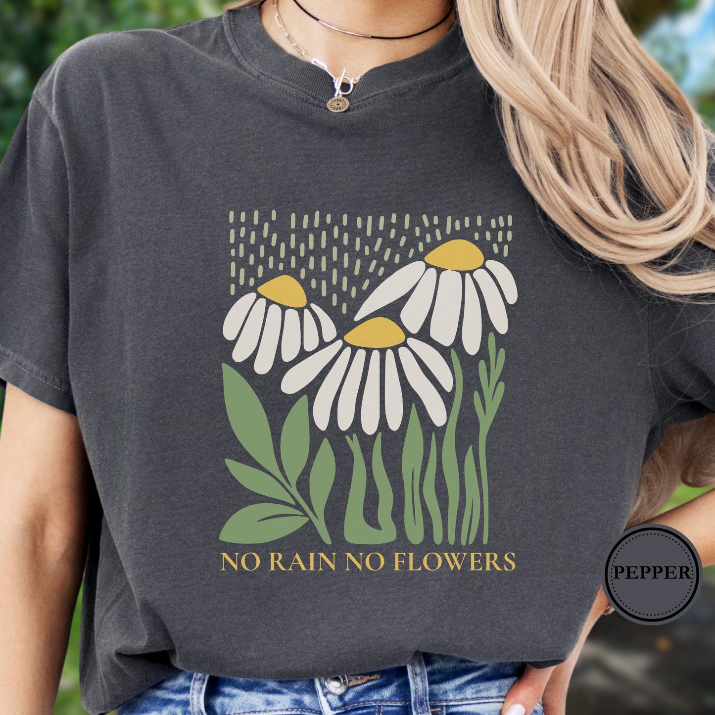 Person wearing a dark gray t-shirt with floral design and 'No Rain No Flowers' text.