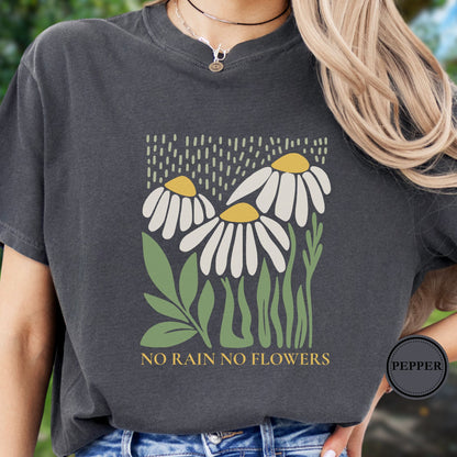 Person wearing a dark gray t-shirt with floral design and 'No Rain No Flowers' text.