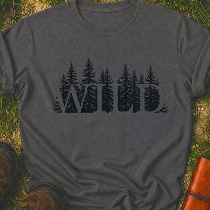 Dark Gray t-shirt with the word WILD cut into a  forest design lying on grass