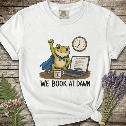 Whte T-shirt with the image of a frod with his fist raised in front of a computer with the phrase "We Book At Dawn"