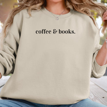 A woman wearing a light beige crewneck sweatshirt with the black text 'coffee & books.' printed across the chest, paired with blue jeans.