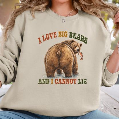 A woman wearing a beige crewneck sweatshirt with a graphic of a brown bear holding a fish, with the text 'I LOVE BIG BEARS AND I CANNOT LIE' in a retro multicolor font.