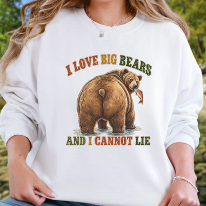 A woman wearing a white long-sleeve crewneck sweatshirt with a graphic of a brown bear holding a fish and the text 'I LOVE BIG BEARS AND I CANNOT LIE' in orange and green lettering.